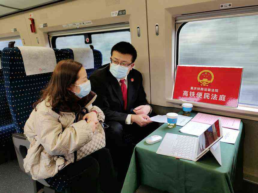 12月13日，从重庆开往成都的G310次列车上，高铁便民法庭法官正在解答群众疑惑。重庆铁路运输法院供图