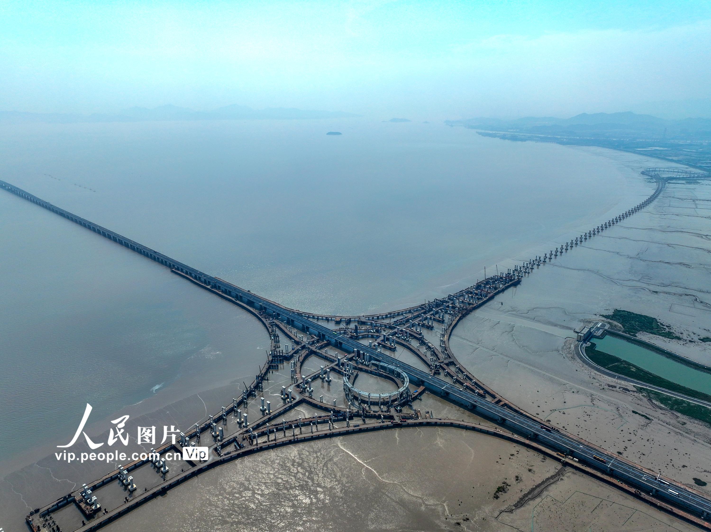浙江省交通集团杭甬复线宁波一期项目滨海互通施工现场，正在架设箱梁的匝道犹如一弯鹅毛月镶嵌海中，蔚为壮观。