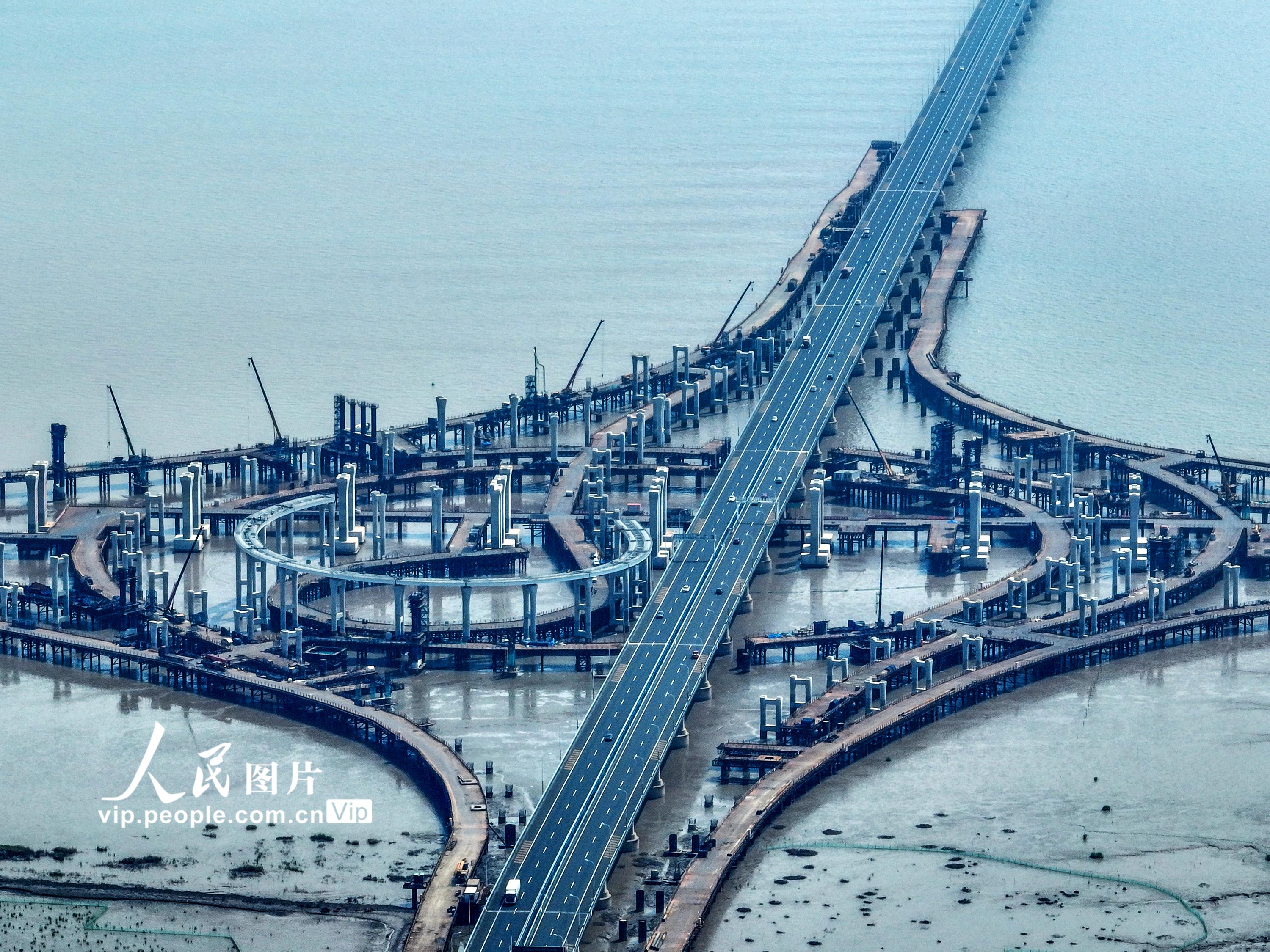 浙江省交通集团杭甬复线宁波一期项目滨海互通施工现场，正在架设箱梁的匝道犹如一弯鹅毛月镶嵌海中，蔚为壮观。