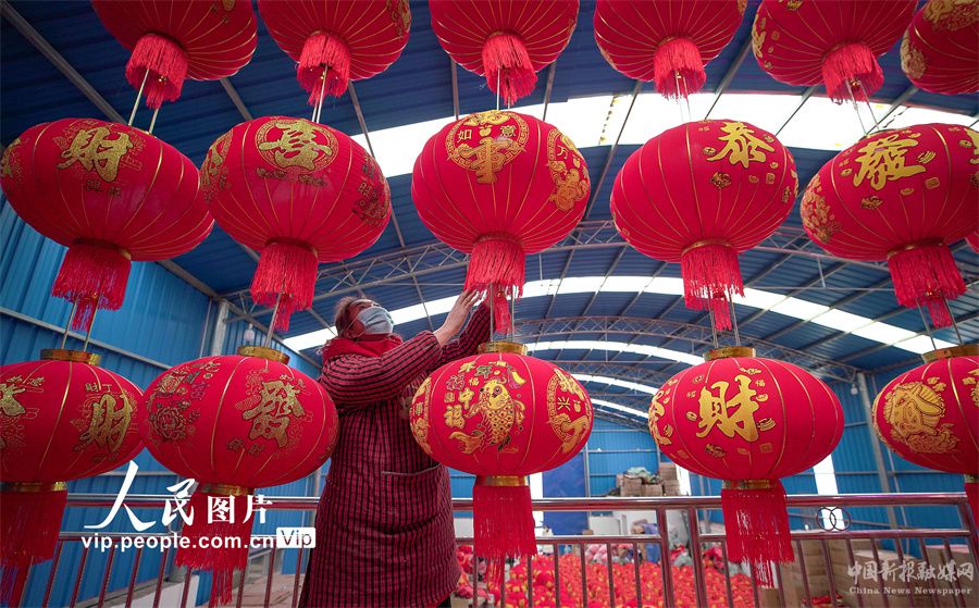 12月22日，贵州省黔东南苗族侗族自治州丹寨县金钟经济开发区一家灯笼厂，工人在检查灯笼成品的质量。